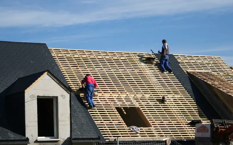 Couvreur professionnel travaillant sur une toiture en renovation